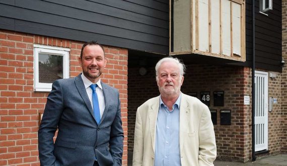 Grant Sutton (left) and Michael Poole at Nicholsons Grove, where the timber cladding is in the process of being replaced. The black boarded section is the new cement-based replacement cladding.