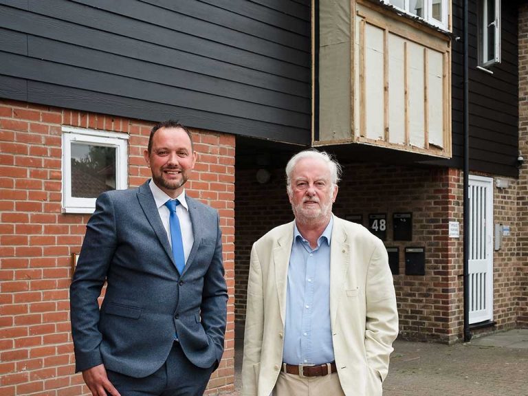 Grant Sutton (left) and Michael Poole at Nicholsons Grove, where the timber cladding is in the process of being replaced. The black boarded section is the new cement-based replacement cladding.